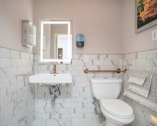A modern bathroom featuring a toilet, sink, and stylish marble tiles.