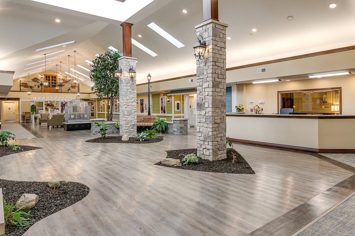 A spacious, modern lobby featuring stone pillars and indoor plants.