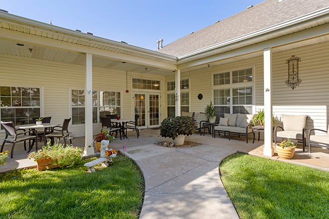 A cozy and inviting residential patio area with comfortable outdoor seating and a well-maintained garden.