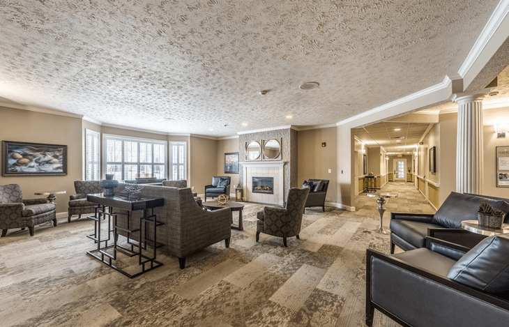A spacious living room with comfortable seating, a fireplace, and large windows.