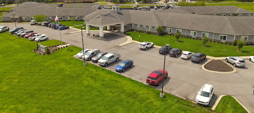 Aerial view of a hotel with a spacious parking lot and well-maintained lawn.