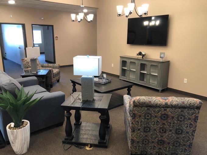 A cozy living room with comfortable seating, a television, and decorative lighting.