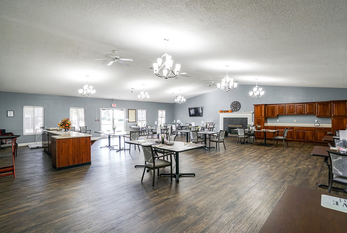 Spacious dining hall with multiple tables and chandeliers.
