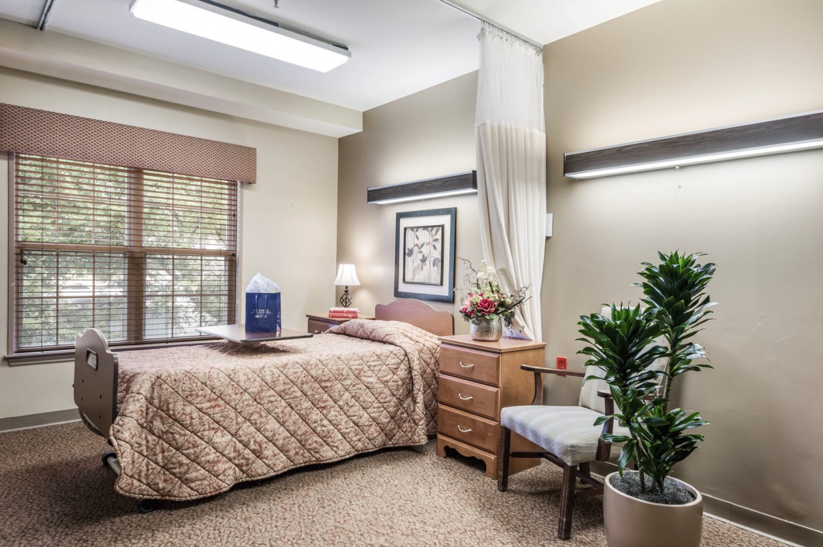 A cozy and well-decorated bedroom with a bed, nightstand, and potted plant.