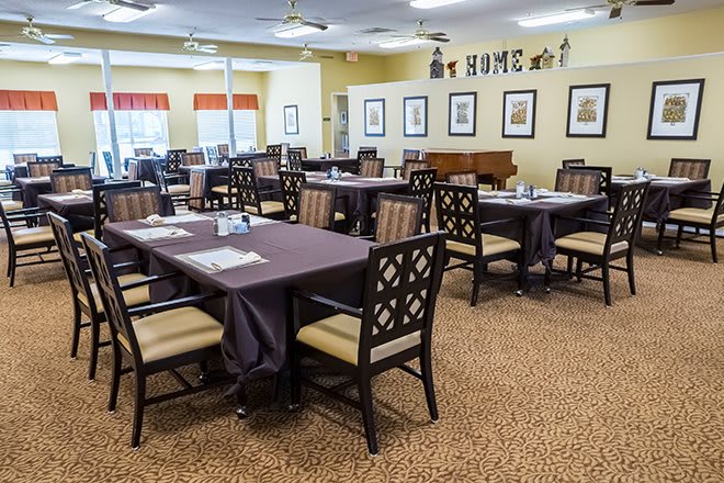 An empty dining room with neatly arranged tables and chairs in a well-lit interior.