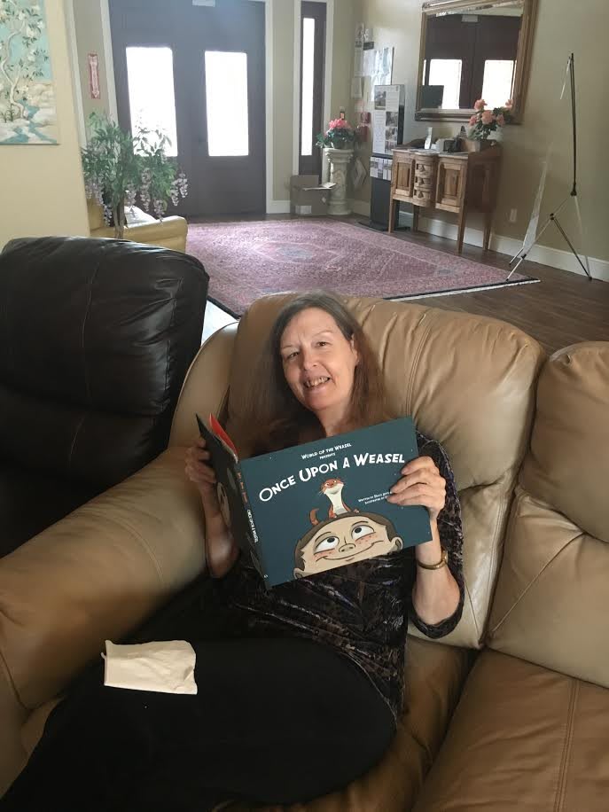 A woman relaxing on a couch while reading a book in the living room.
