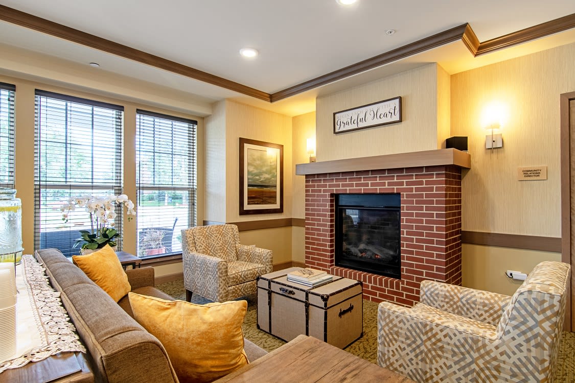 A cozy living room featuring a brick fireplace, comfortable seating, and tasteful decor.
