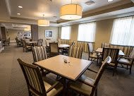 A well-lit dining area with neatly arranged tables and chairs.