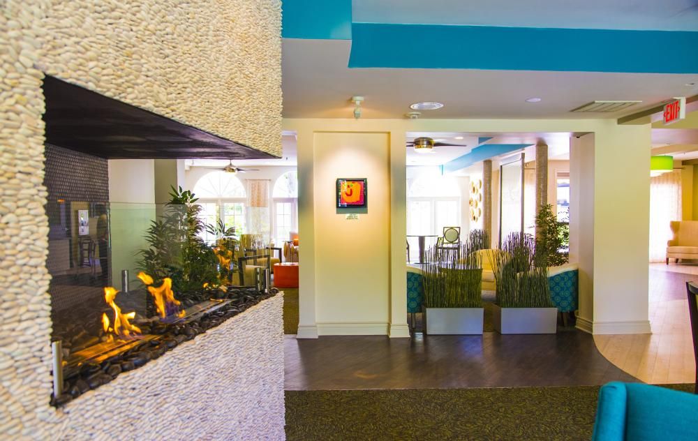 A modern lobby interior featuring artwork, decorative plants, and stylish lighting.