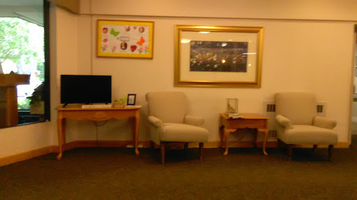 A cozy living room setup featuring comfortable chairs, a television, and decorative artwork on the walls.