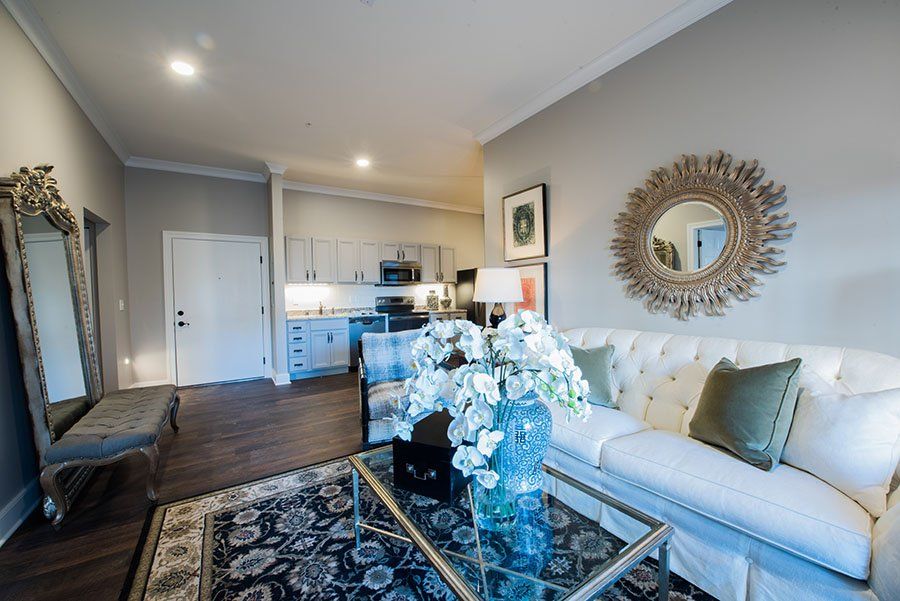 A modern living room with a comfortable couch, stylish decor, and an open kitchen in the background.