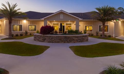 A beautifully lit house during the evening with well-maintained landscaping.
