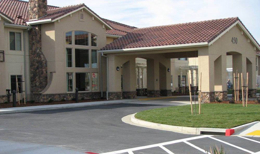 A modern building with a tiled roof and large windows at the entrance.