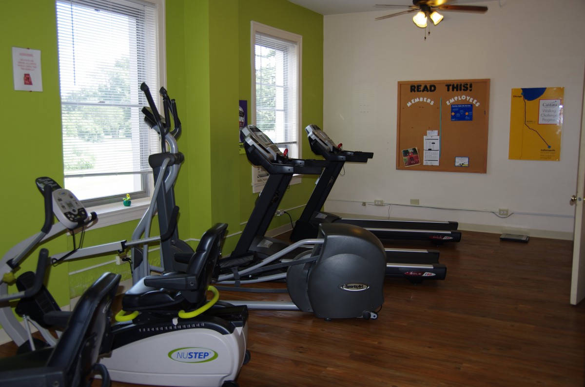 A gym room with treadmills and an elliptical machine.