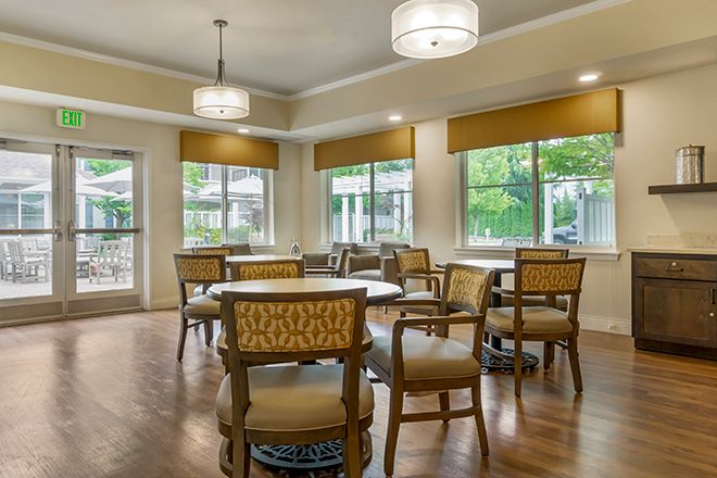 A cozy dining room with elegant furnishing and large windows.