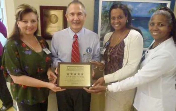 A group of individuals holding a plaque, celebrating an achievement.