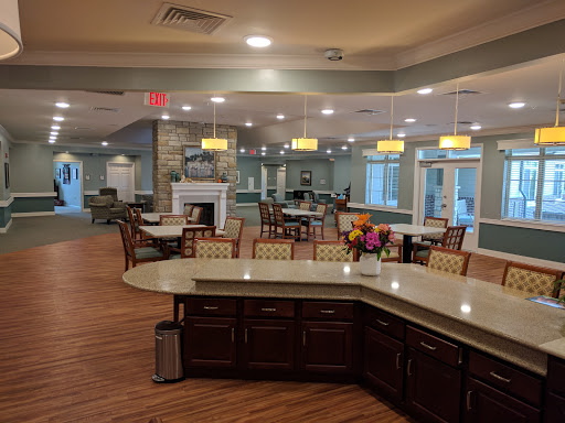 A spacious and inviting dining area featuring modern furnishings and bright lighting.