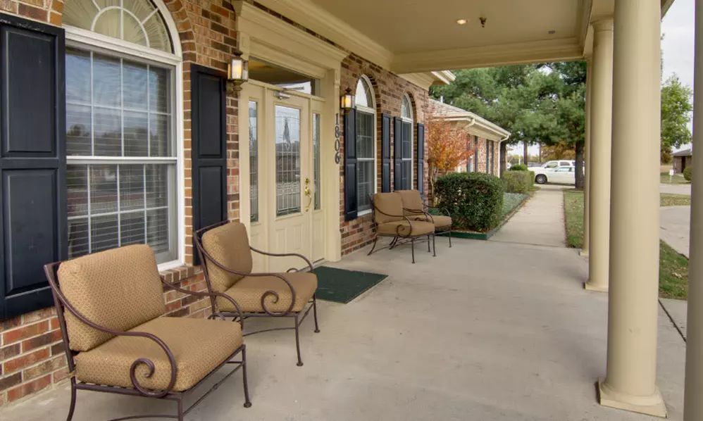 A cozy entrance with outdoor seating on a covered porch.