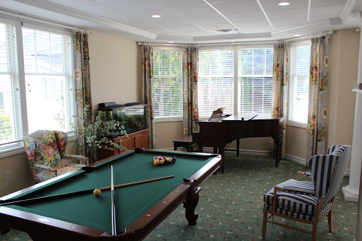 A bright and inviting game room featuring a pool table and piano, perfect for relaxation and entertainment.