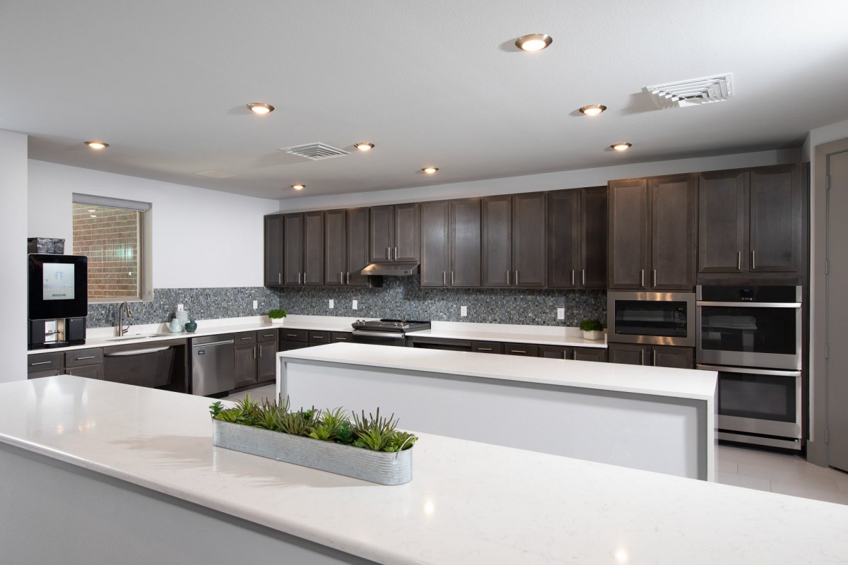 A modern kitchen with sleek countertops and dark wood cabinets.