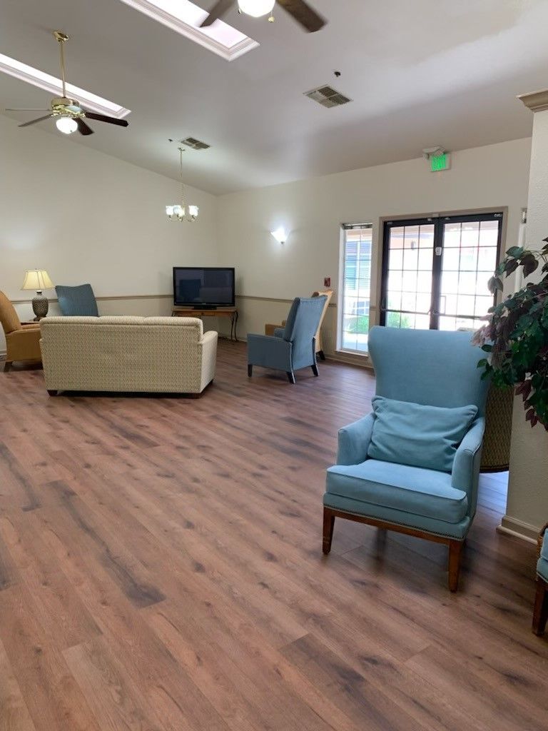 A cozy living room with comfortable seating, a television, and wooden flooring.