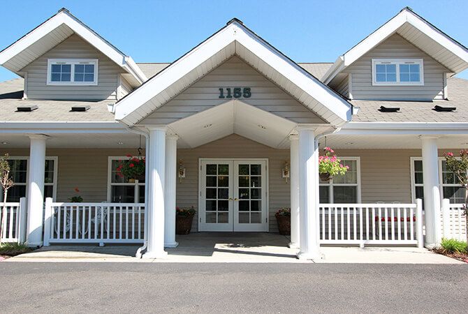 The front entrance of a building with large white columns and a covered porch.
