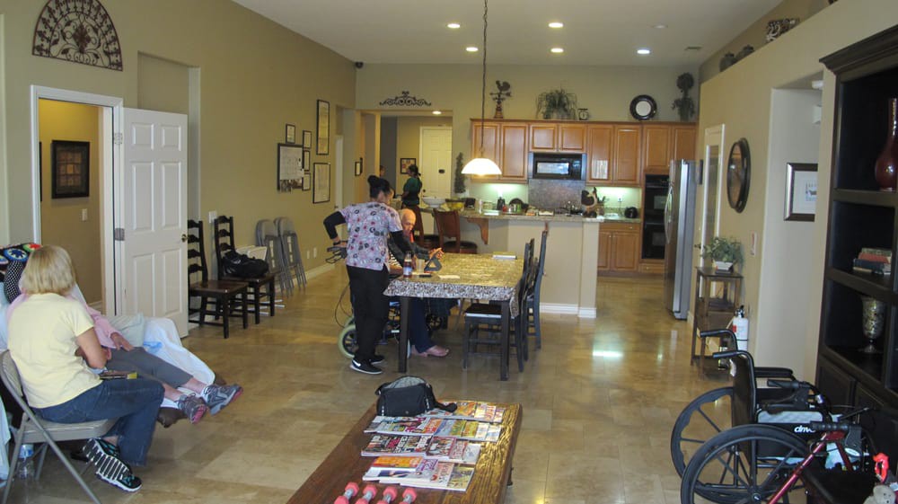 A modern kitchen and dining area with people preparing food.
