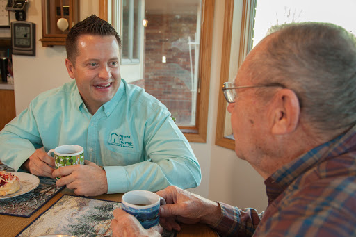 Two men engaged in a friendly conversation over coffee in a cozy indoor setting.
