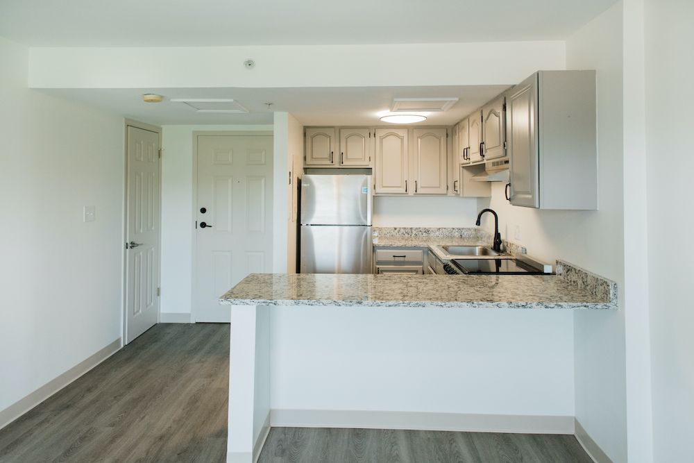 A modern kitchen in an apartment with stainless steel appliances and granite countertops.