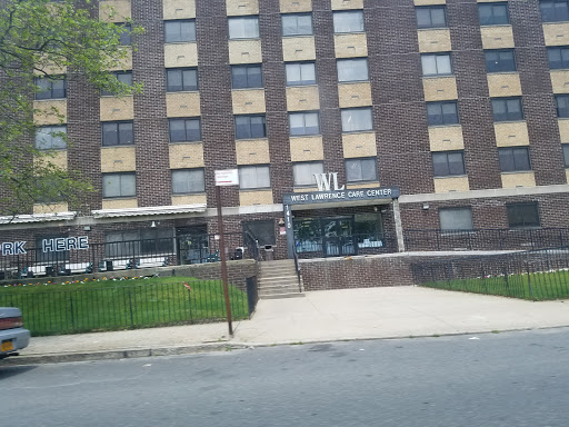 An apartment building featuring a brick facade with boarded windows.