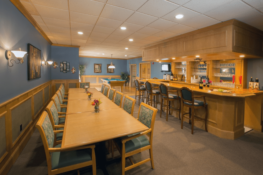 Spacious dining and bar area with blue walls and wooden furniture.