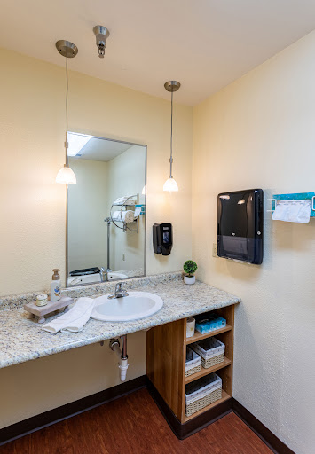 A modern bathroom featuring a sleek sink, stylish lighting, and organized storage.