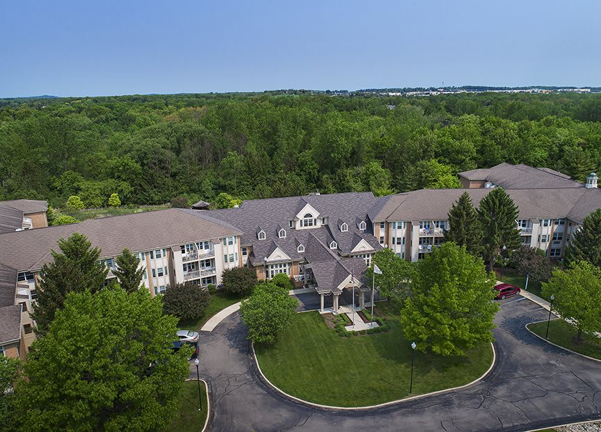 Aerial view of a residential building surrounded by lush greenery.