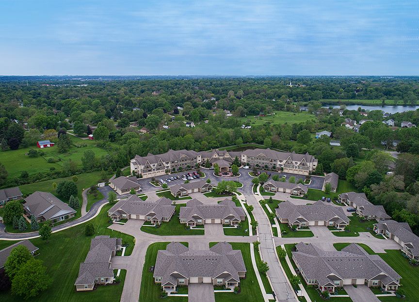 An aerial view of a suburban residential neighborhood surrounded by lush greenery.