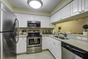 A modern kitchen with stainless steel appliances and white cabinetry.