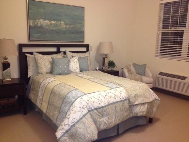 A cozy bedroom with a neatly made bed, soft lighting, and tasteful artwork.