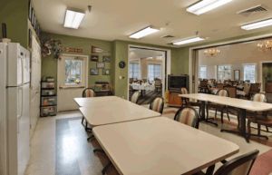A communal meeting room with tables and chairs arranged for group activities.