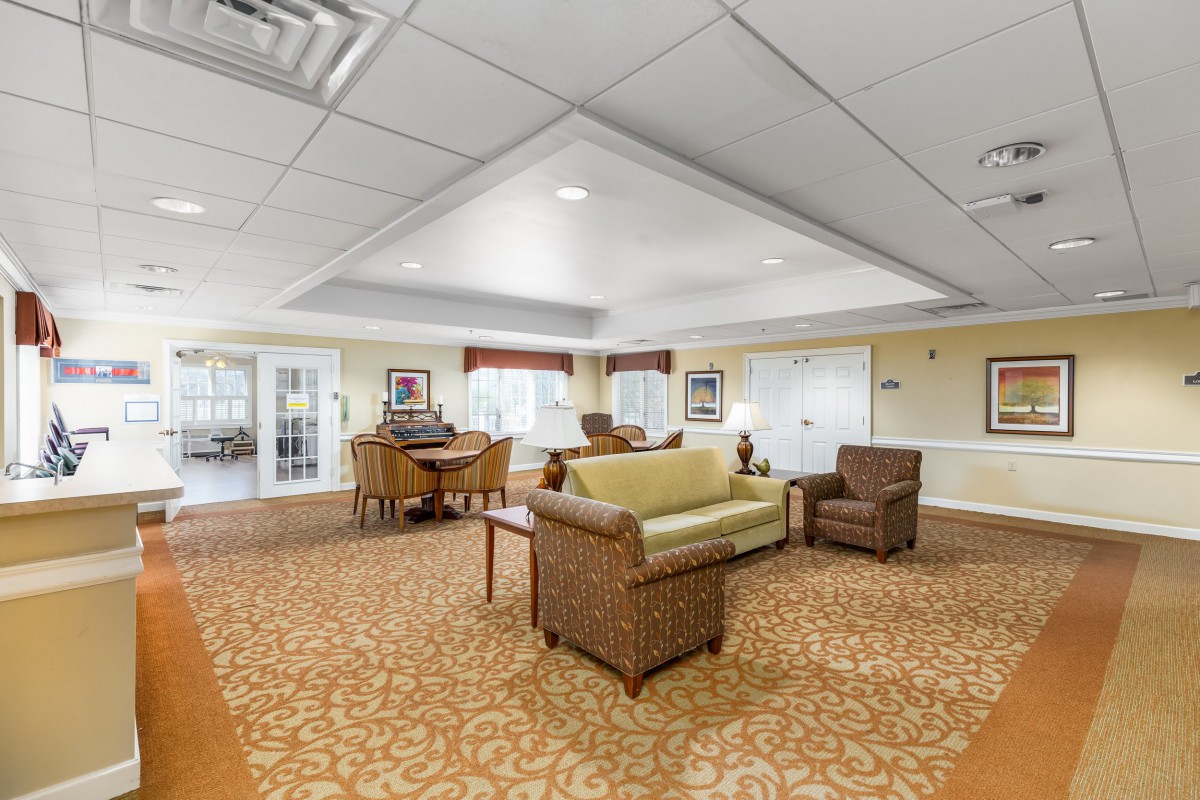 A well-lit living room with cozy seating and a patterned carpet.