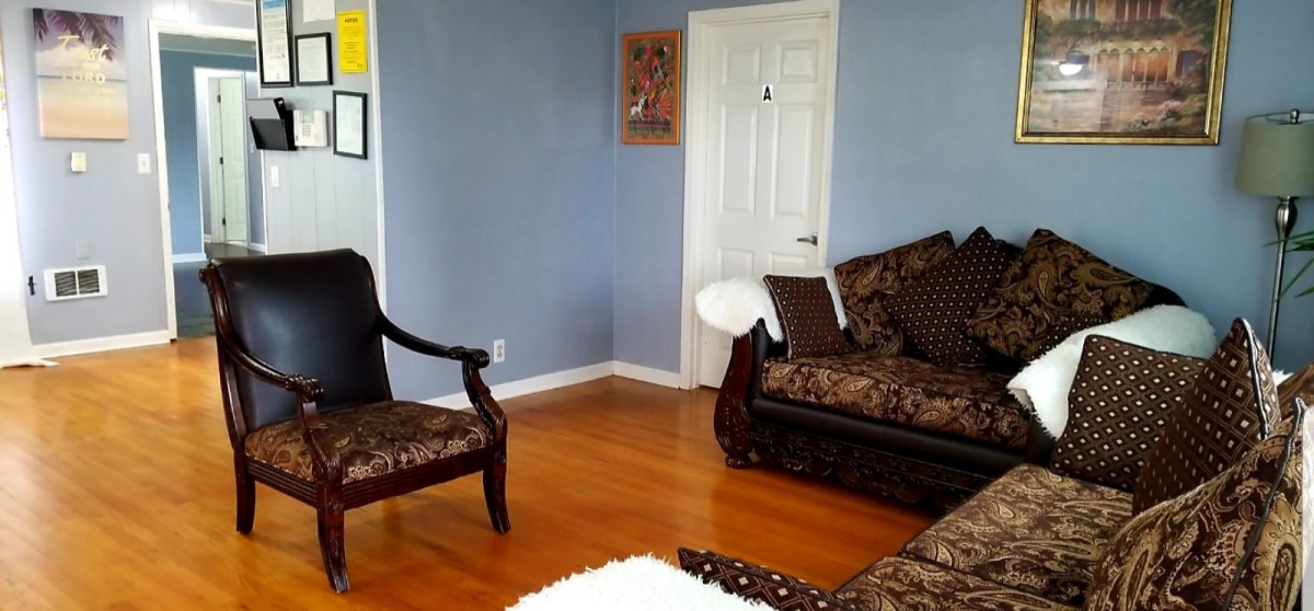 A cozy living room with blue walls, featuring elegant furniture and a hardwood floor.