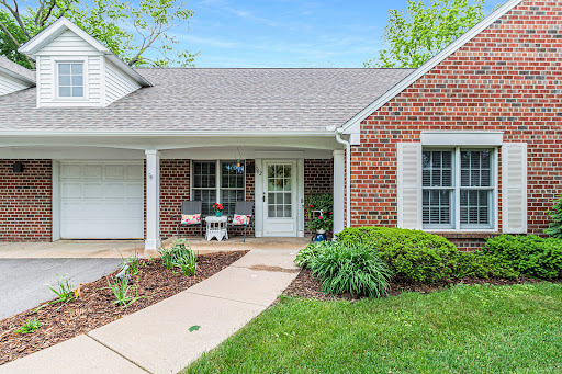 A charming brick house with a welcoming front porch and well-maintained landscaping.