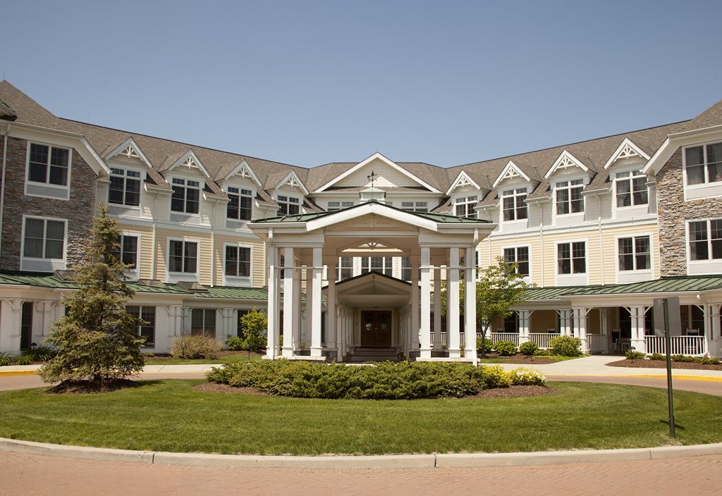A symmetrical residential building with a landscaped front entrance.