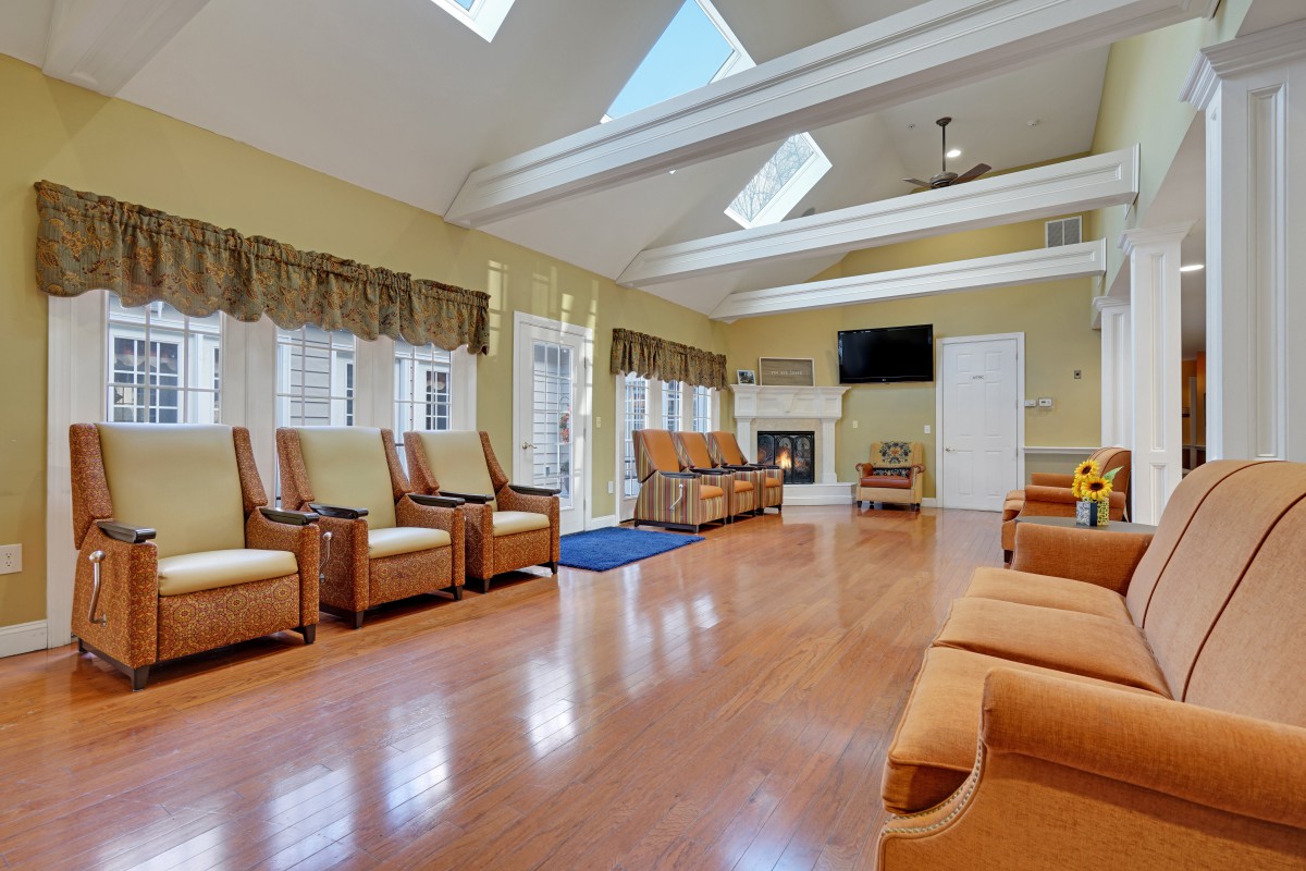 A spacious living room with skylights, wooden flooring, and comfortable seating.