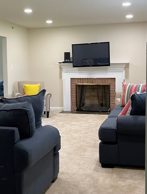 A cozy living room featuring a fireplace, television, and comfortable seating.