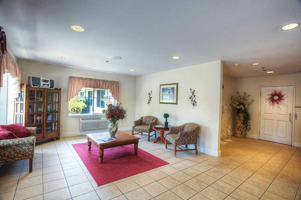 A cozy and well-lit lobby area with chairs, a table, and decorative elements.