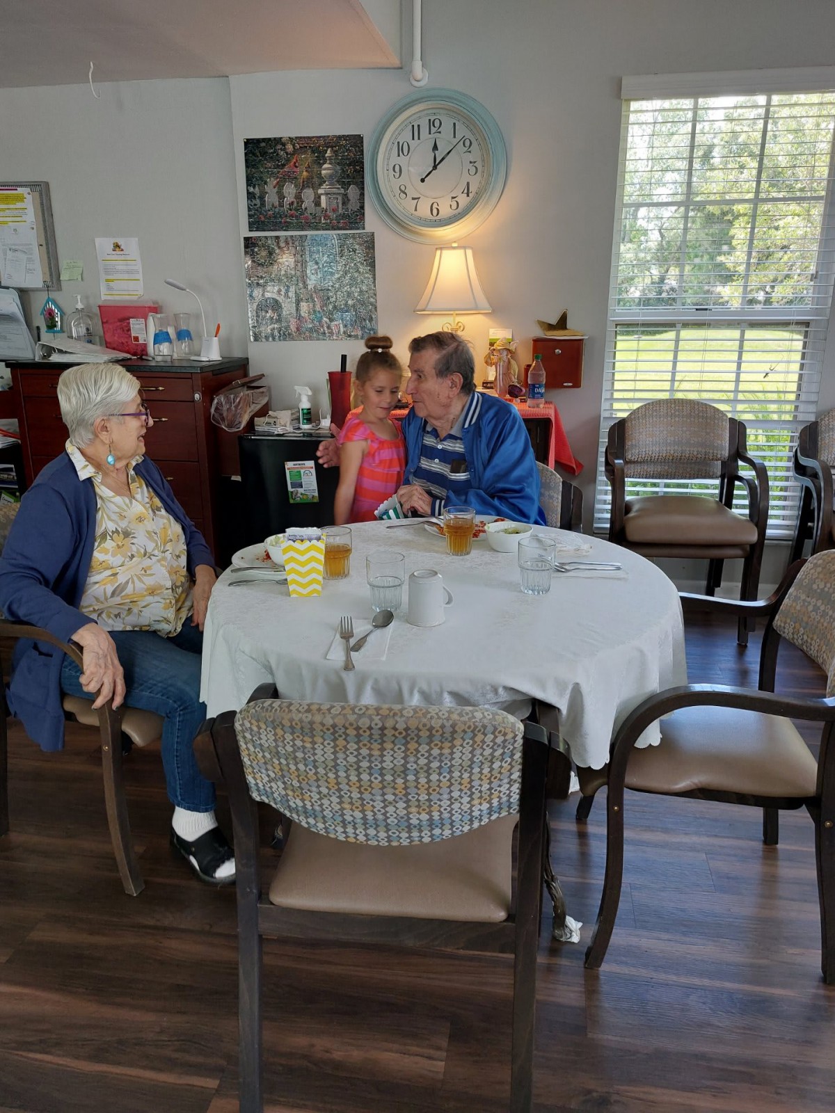A family gathering around a dining table sharing a moment together.