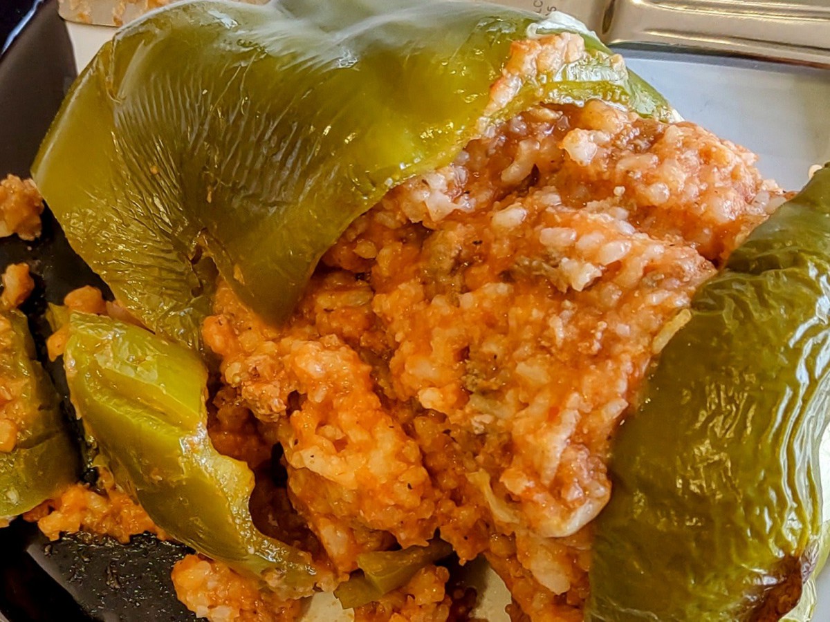 A close-up view of a green bell pepper stuffed with a savory mixture, including rice.