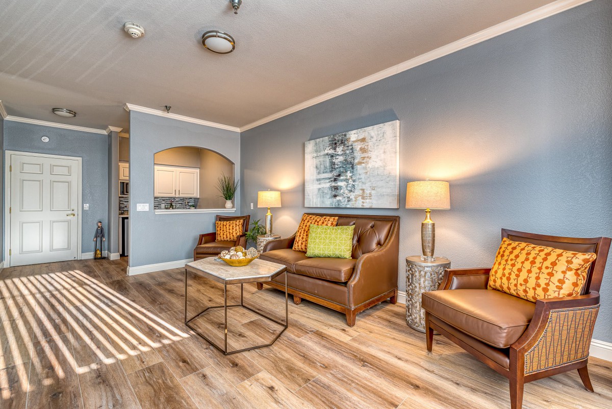 A cozy and modern living room with wood flooring, stylish furniture, and warm lighting.