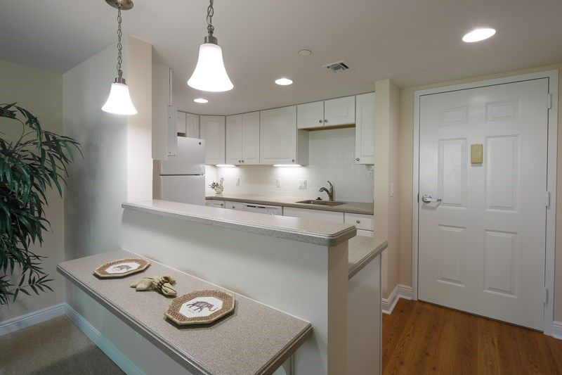 Modern kitchen with sleek countertops and pendant lighting.