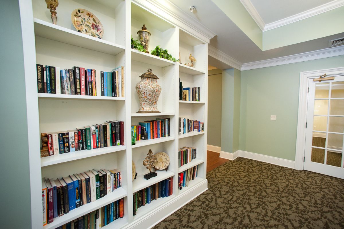 A cozy hallway featuring built-in bookshelves filled with books and decorative items.