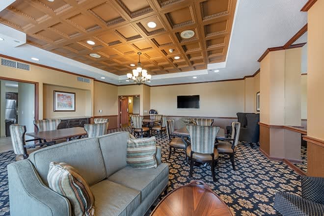 A cozy hotel lounge featuring comfortable seating and a TV.